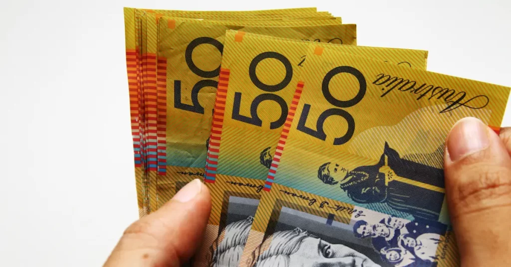 a hand holding bundle of Australian dollars