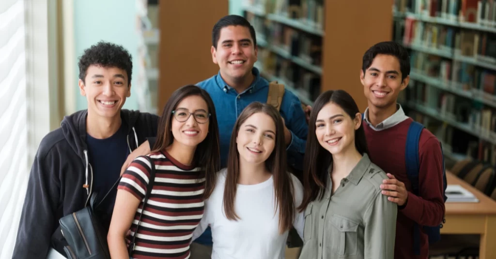 horizontal image of university students standing in library facing the camera