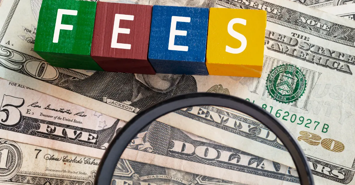 colourful wooden cube block with fees words on stacked of banknotes