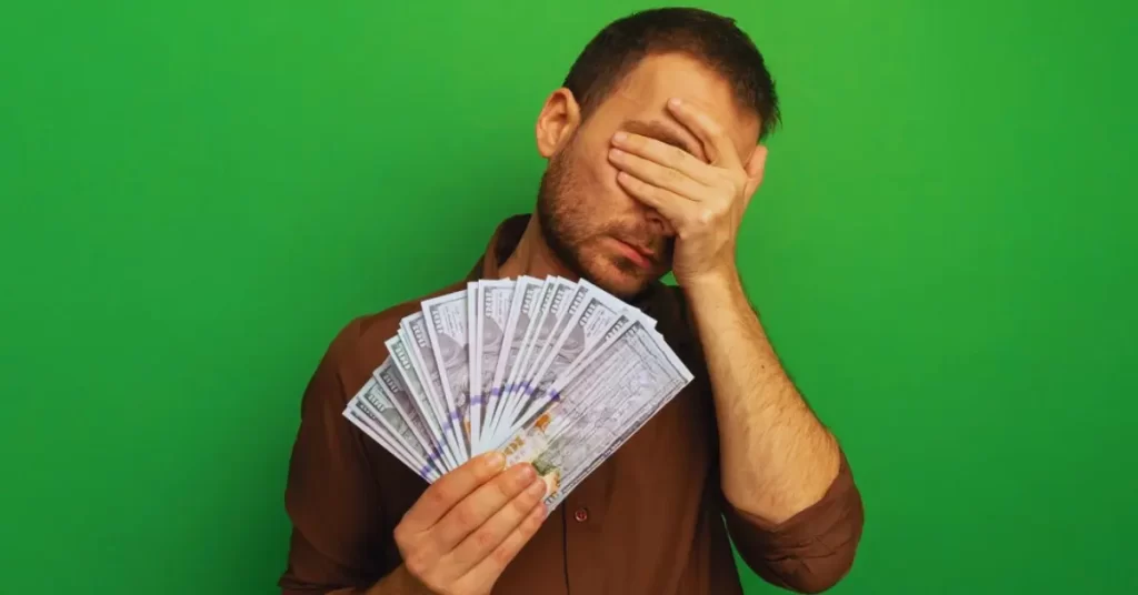 disappointed man holding currencies
