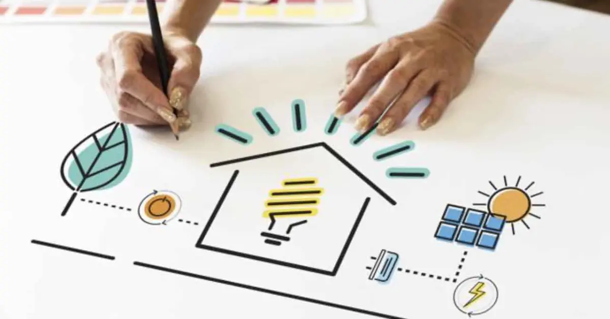 A person sketches a house featuring solar panels on the roof and a light bulb, symbolizing sustainable energy solutions.